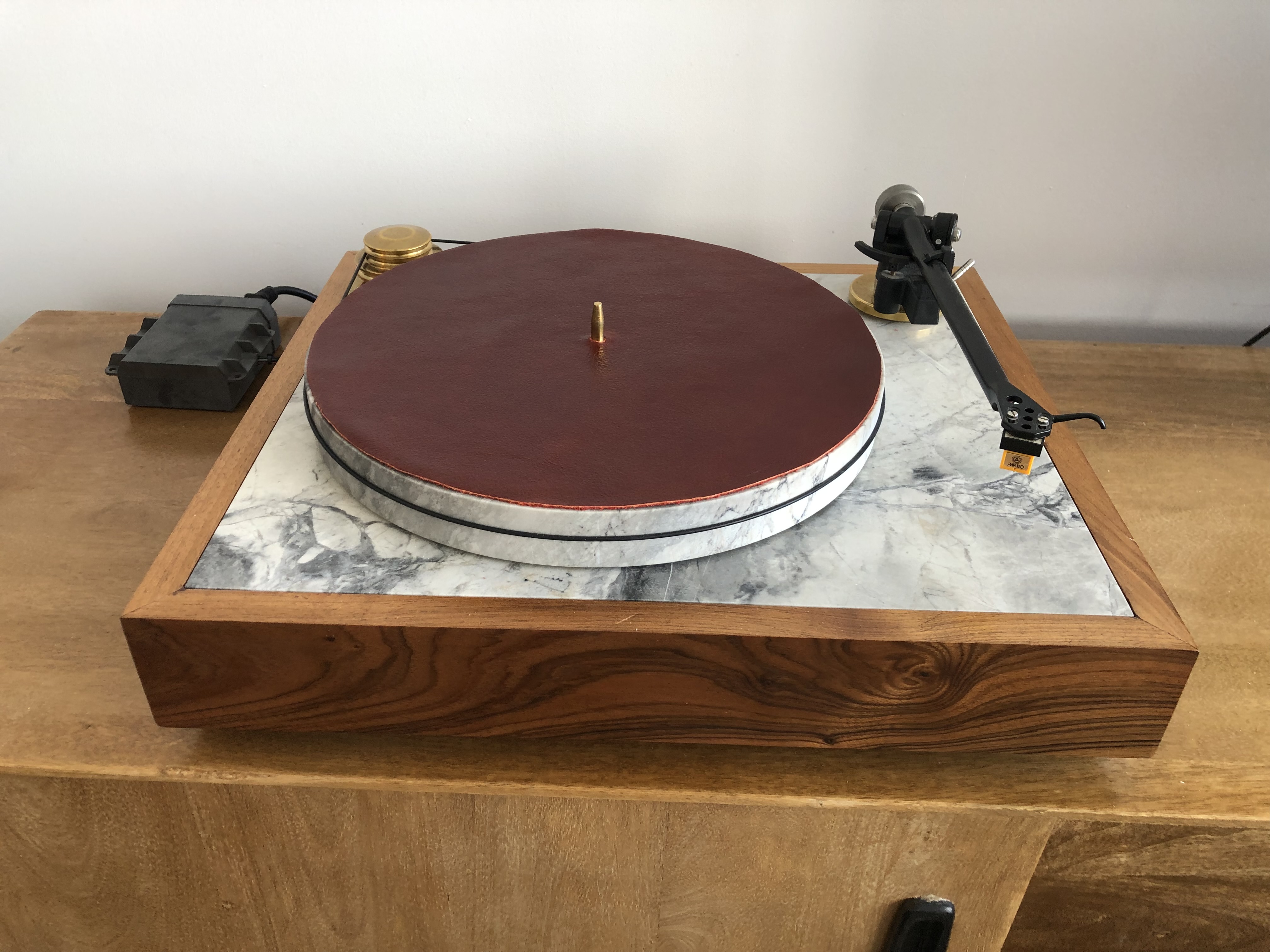 Burgundy leather platter mat on marble turntable, three-quarter view